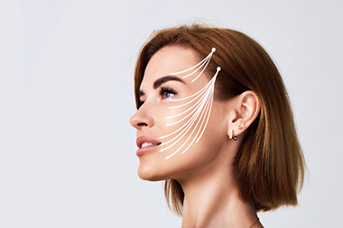 Beautiful woman with perfect clean skin and lifting arrows over her face on gray background. Face Lifting. copy space